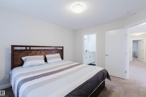 This room features light colored carpeting and white walls, creating a bright and airy atmosphere - 2878 Koshal Crescent, Edmonton, AB - Indoor Photo Showing Bedroom