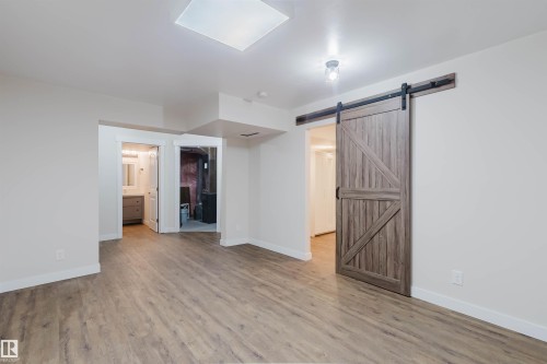 This area features light-colored walls, a skylight, and plank flooring - 2878 Koshal Crescent, Edmonton, AB - Indoor Photo Showing Other Room