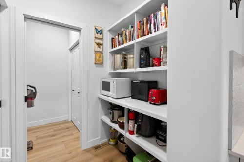 A spacious pantry with white shelving provides ample storage - 345 Meadowview Drive, Fort Saskatchewan, AB - Indoor