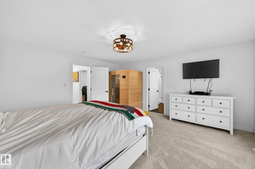 Bedroom featuring light-colored carpet, a ceiling light fixture, and a wooden sauna unit - 345 Meadowview Drive, Fort Saskatchewan, AB - Indoor Photo Showing Bedroom