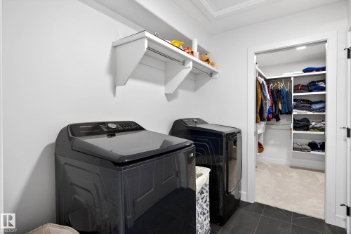 Laundry area featuring dark tiled flooring, light walls, and two large appliances - 345 Meadowview Drive, Fort Saskatchewan, AB - Indoor
