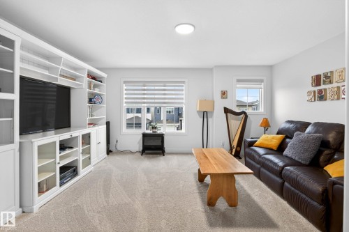Living area featuring light-colored carpet, white walls, and two windows with blinds - 345 Meadowview Drive, Fort Saskatchewan, AB - Indoor Photo Showing Living Room
