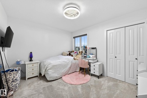 This room features a window providing natural light, a ceiling light fixture, and carpeted flooring - 345 Meadowview Drive, Fort Saskatchewan, AB - Indoor Photo Showing Bedroom