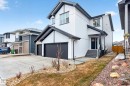 The property features a white exterior with dark trim, an attached garage, and a concrete driveway - 345 Meadowview Drive, Fort Saskatchewan, AB  - Outdoor 