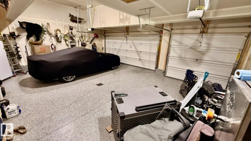 This garage features a durable speckled floor finish and two white garage doors - 345 Meadowview Drive, Fort Saskatchewan, AB - Indoor Photo Showing Garage