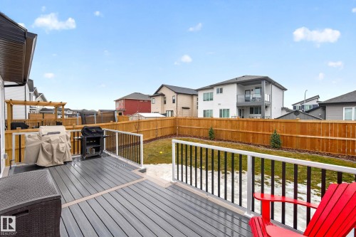 The property features a spacious deck with composite decking and white railings, overlooking a fenced yard with a lawn - 345 Meadowview Drive, Fort Saskatchewan, AB - Outdoor With Exterior