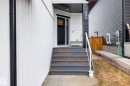 The property features a dark-colored front door with glass panels, complemented by a white exterior facade - 345 Meadowview Drive, Fort Saskatchewan, AB  - Outdoor 