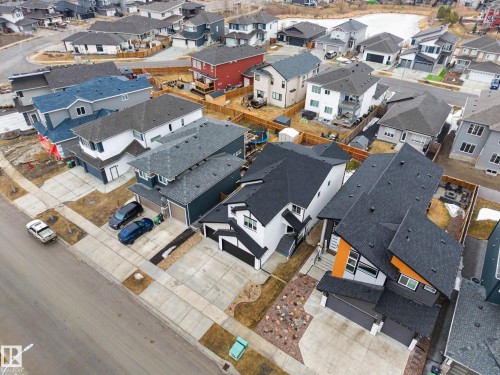 This aerial view showcases the property's modern exterior design with a black roof and contrasting orange and white facade elements - 345 Meadowview Drive, Fort Saskatchewan, AB - Outdoor With View