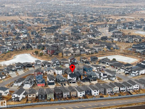 Aerial view of the property and surrounding neighborhood, featuring residential homes and two ponds - 345 Meadowview Drive, Fort Saskatchewan, AB - Outdoor With View