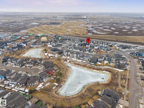 Aerial view of the community, showcasing residences, two ponds, and surrounding open land - 345 Meadowview Drive, Fort Saskatchewan, AB - Outdoor With View