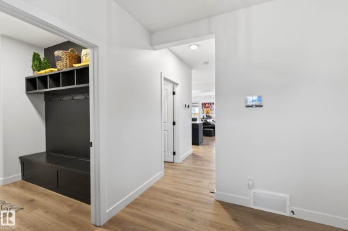 Entryway featuring hardwood flooring and a built-in dark wood coat rack with storage cubbies and bench seating - 345 Meadowview Drive, Fort Saskatchewan, AB - Indoor Photo Showing Other Room