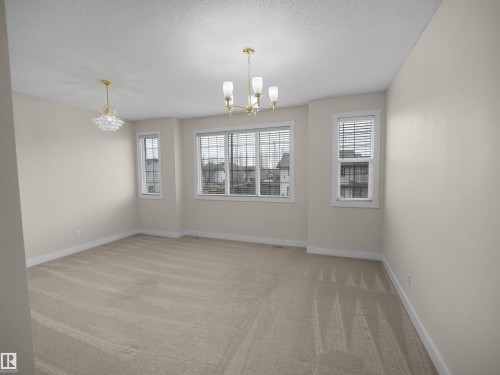 The property features soft neutral-toned walls, plush carpeting, and windows with blinds - 8361 Shaske Crescent, Edmonton, AB - Indoor Photo Showing Other Room