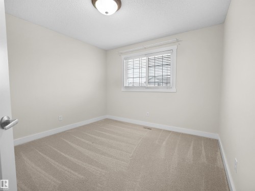 This room features neutral-toned carpet, light-colored walls, and a window with blinds - 8361 Shaske Crescent, Edmonton, AB - Indoor Photo Showing Other Room