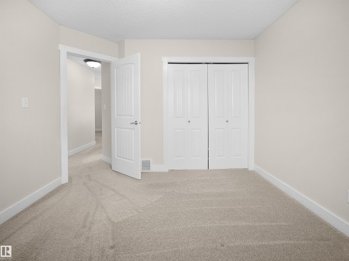 This room features neutral-toned carpet flooring, light beige walls, and white trim throughout - 8361 Shaske Crescent, Edmonton, AB - Indoor