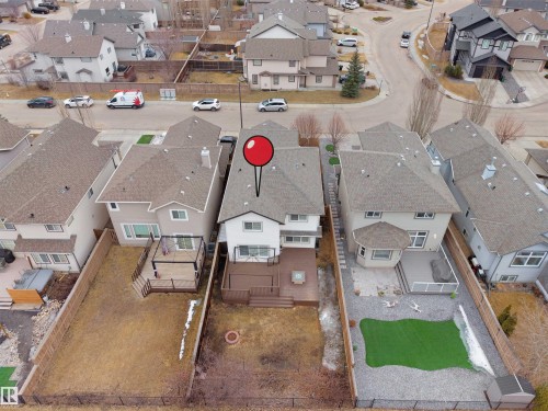 Aerial view of the property and surrounding neighborhood, featuring residential streets, houses with various roof styles, and a mix of paved and unpaved areas - 8361 Shaske Crescent, Edmonton, AB - Outdoor With View