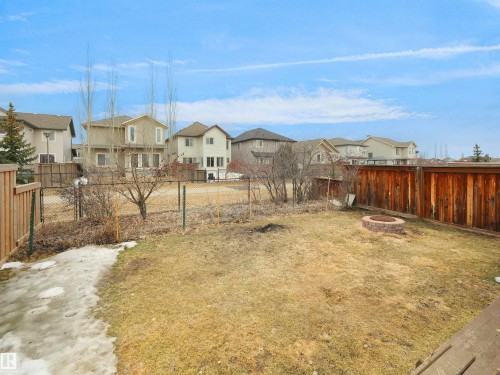 The property features a spacious yard with a grass area and a brick fire pit - 8361 Shaske Crescent, Edmonton, AB - Outdoor