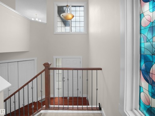 Foyer with wood flooring, a decorative stained glass window, and a chandelier - 8361 Shaske Crescent, Edmonton, AB - Indoor Photo Showing Other Room