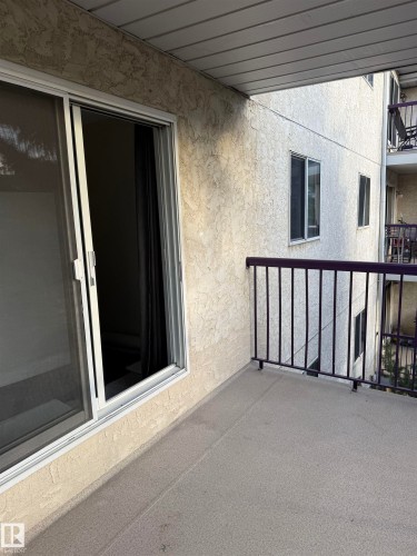 The property features a private balcony with a dark railing and a sliding glass door for access - 331 10636 120 Street, Edmonton, AB - Outdoor With Balcony With Exterior
