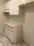 Kitchen area featuring white cabinetry with gold-toned trim, a light-colored countertop, and a range hood - 331 10636 120 Street, Edmonton, AB  - Indoor 