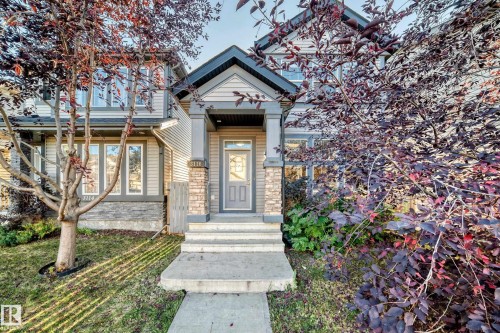 The property features an inviting entrance with a covered porch and stone accents - 3116 Arthurs Crescent, Edmonton, AB 