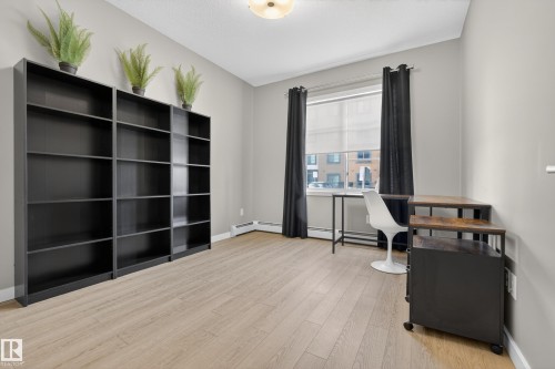This room features light-colored flooring, a window with a roller blind and dark curtains, and a ceiling light fixture - 127 1154 Adamson Drive, Edmonton, AB - Indoor