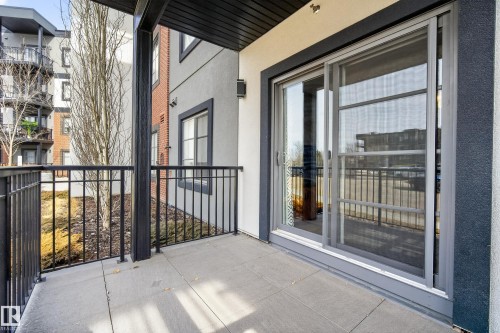 This property features a private balcony with durable tile flooring and black metal railings, offering a pleasant outdoor space - 127 1154 Adamson Drive, Edmonton, AB - Outdoor With Balcony With Exterior