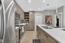This kitchen features stainless steel appliances, including a refrigerator, microwave, and oven - 127 1154 Adamson Drive, Edmonton, AB  - Indoor Photo Showing Kitchen With Stainless Steel Kitchen With Double Sink With Upgraded Kitchen 