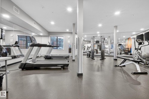 The property features a well-equipped fitness center with various exercise machines, including treadmills, an elliptical, and weight benches - 127 1154 Adamson Drive, Edmonton, AB - Indoor Photo Showing Gym Room