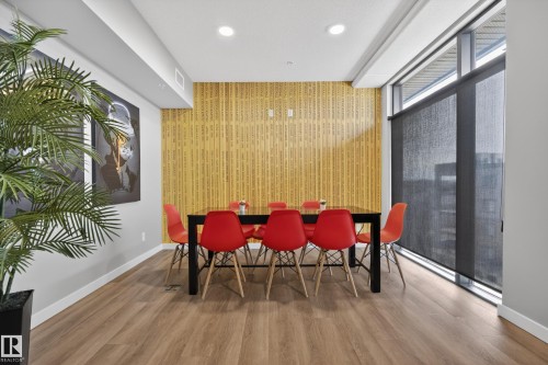 Well-lit space featuring hardwood flooring, a unique textured wall, and expansive windows with roller shades - 127 1154 Adamson Drive, Edmonton, AB - Indoor