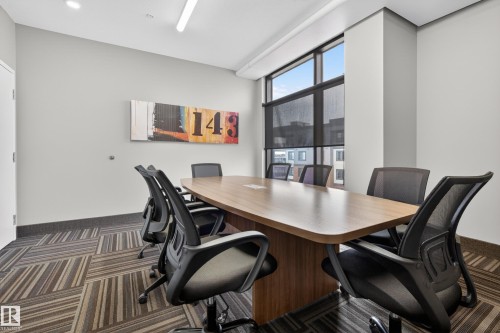 Conference room featuring a large table, multiple office chairs, and patterned carpeting - 127 1154 Adamson Drive, Edmonton, AB - Indoor Photo Showing Office