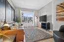 Living area featuring light-toned flooring, a sliding glass door providing access to an exterior balcony, and light gray walls - 127 1154 Adamson Drive, Edmonton, AB  - Indoor 