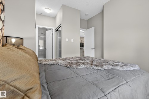 This bedroom features light gray walls and a ceiling light fixture - 127 1154 Adamson Drive, Edmonton, AB - Indoor Photo Showing Bedroom