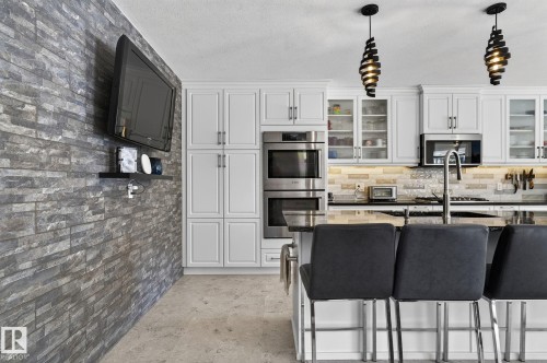 The kitchen features white cabinetry, stainless steel appliances, and a dark countertop - 19 Escada Close, St. Albert, AB - Indoor Photo Showing Kitchen With Upgraded Kitchen