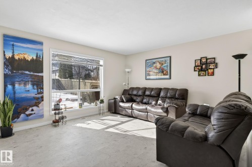 The living area features a large window, light-colored walls, and a light-colored carpet - 19 Escada Close, St. Albert, AB - Indoor Photo Showing Living Room