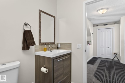 The bathroom features a modern vanity with a white countertop and a framed mirror - 19 Escada Close, St. Albert, AB - Indoor Photo Showing Bathroom