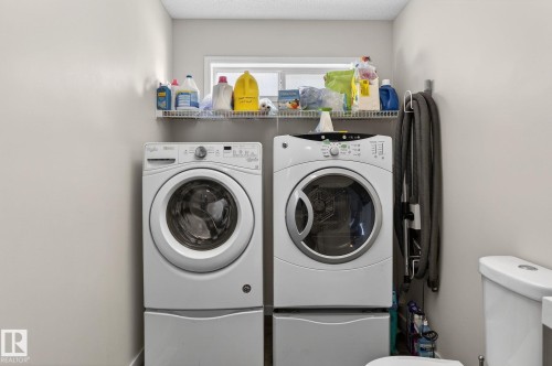 Dedicated laundry area featuring a front-loading washing machine and dryer, both with pedestals - 19 Escada Close, St. Albert, AB - Indoor Photo Showing Laundry Room