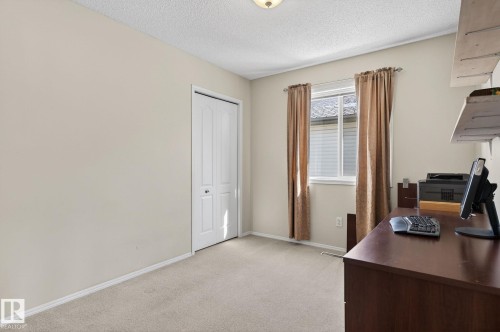 This room features light-colored walls and carpeting, a window with blinds and drapes, and a white bi-fold closet door - 19 Escada Close, St. Albert, AB - Indoor