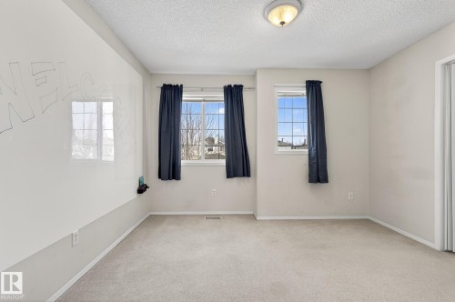 This room features light-colored carpeting, a textured ceiling, and a ceiling light fixture - 19 Escada Close, St. Albert, AB - Indoor Photo Showing Other Room