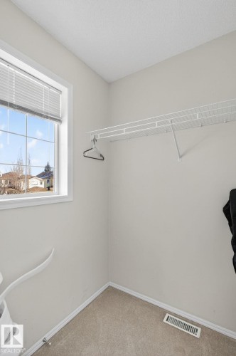A closet space featuring a window with blinds, carpeted flooring, and a wire shelving system - 19 Escada Close, St. Albert, AB - Indoor With Storage