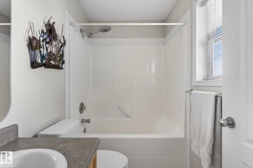 Bathroom featuring a white bathtub and shower combination, a toilet, and a vanity with a sink and countertop - 19 Escada Close, St. Albert, AB - Indoor Photo Showing Bathroom