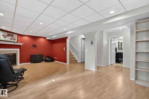 The property features a spacious living area with light-colored flooring, a fireplace with a white mantel, and a dropped ceiling with recessed lighting - 19 Escada Close, St. Albert, AB - Indoor