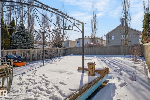 The property features a fenced yard with a metal gazebo frame and a wooden retaining wall - 19 Escada Close, St. Albert, AB - Outdoor