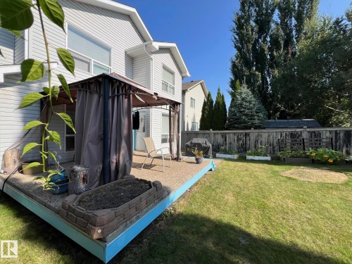 The property features a spacious backyard with a well-maintained lawn and a wooden fence - 19 Escada Close, St. Albert, AB - Outdoor