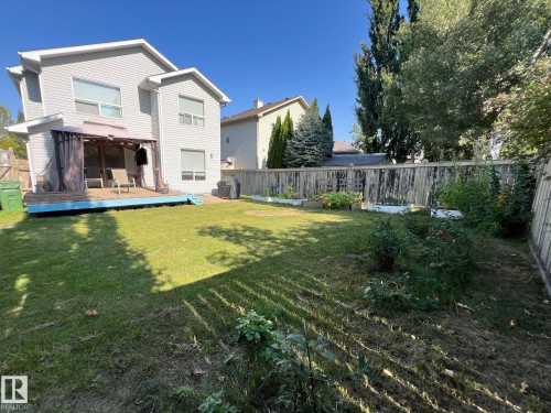 The property features a spacious rear yard with a lawn, a raised deck with a gazebo, and established garden beds - 19 Escada Close, St. Albert, AB - Outdoor With Deck Patio Veranda With Backyard