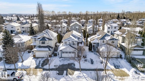 Aerial view of the property and surrounding neighborhood, featuring residential homes with snow-covered roofs and trees - 19 Escada Close, St. Albert, AB - Outdoor With Facade