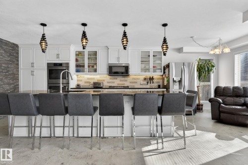 The kitchen features white cabinetry, stainless steel appliances, and a tiled backsplash - 19 Escada Close, St. Albert, AB - Indoor Photo Showing Kitchen With Upgraded Kitchen