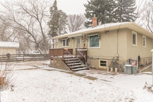 The property features a front deck with railings and steps, a light-colored exterior, and an awning over a window - 11255 71 Avenue, Edmonton, AB - Outdoor