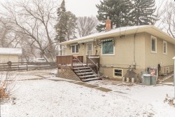 The property features a front deck with railings and steps, a light-colored exterior, and an awning over a window - 
