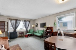 The living area features a broad window with ample natural light and a neutral color palette - 