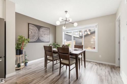 The property features a dining area with wood-look flooring and a window providing natural light - 3247 Cherry Crescent, Edmonton, AB - Indoor Photo Showing Dining Room
